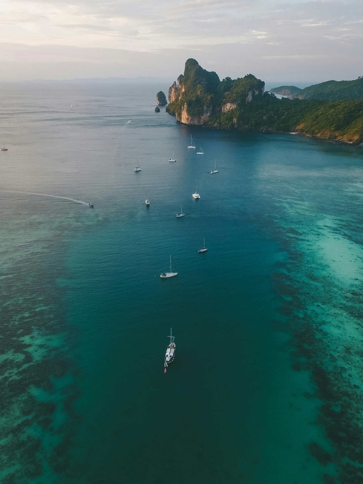 white boats on ocean water under gray sky